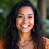 Portrait of Amara Blackwood, an insightful female cultural guide with kind eyes and an open demeanor, wearing traditional-inspired attire, representing deep connection to indigenous knowledge.
